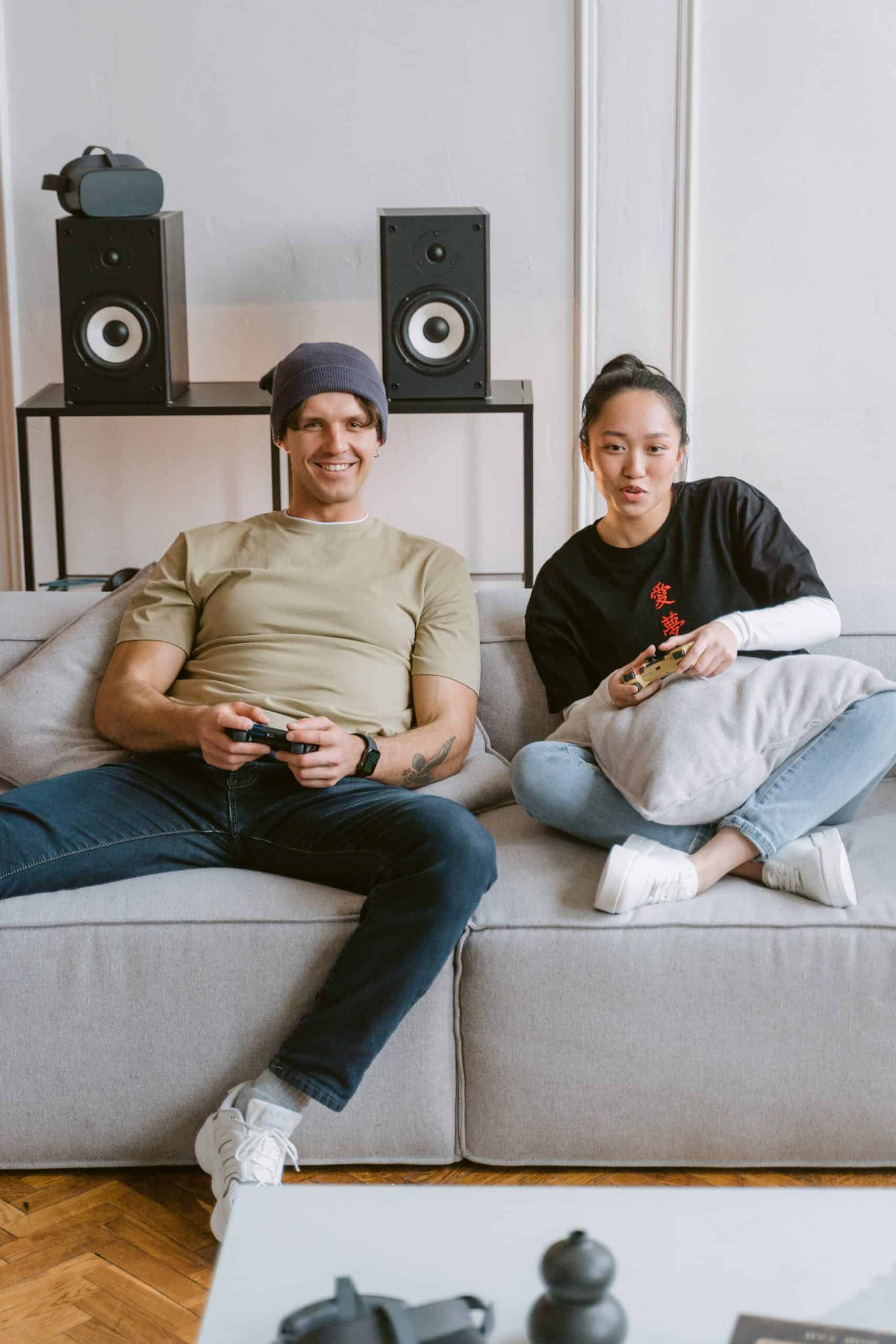 Image from Pexels by Tima Miroshnichenko. A couple places a console game together while sitting on a couch.